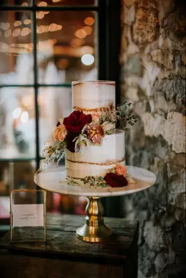 two tier elegant fall wedding cake with red roses and orange orchids