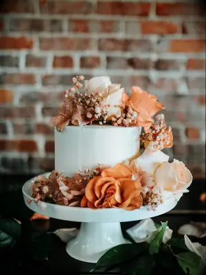 simple one-tier fall wedding cake decorated with orange roses and baby