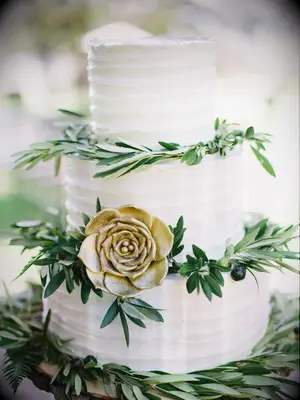 three-tier buttercream fall wedding cake decorated with olive branches and gold sugar flower