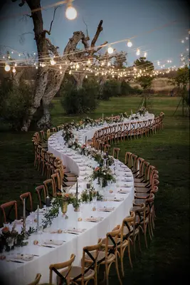 Serpentine table with white table cloth and minimalistic flowers