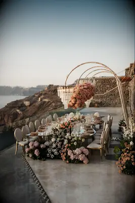 Mirrored serpentine table at outdoor wedding with vibrant flower bouquets
