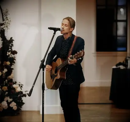 Man singing and playing guitar at wedding