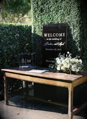 minimalist wedding gift table with black acrylic welcome sign, acrylic card box and white rose centerpiece