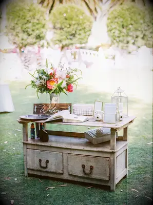vintage wooden sideboard repurposed as wedding gift table with guest book and welcome sign