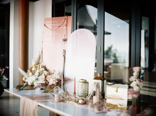 boho wedding gift table with arched wedding seating chart, gold acrylic card box, dried flowers and pink taper candles