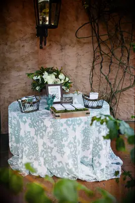 wedding welcome table decorated with blue and white patterned tablecloth 