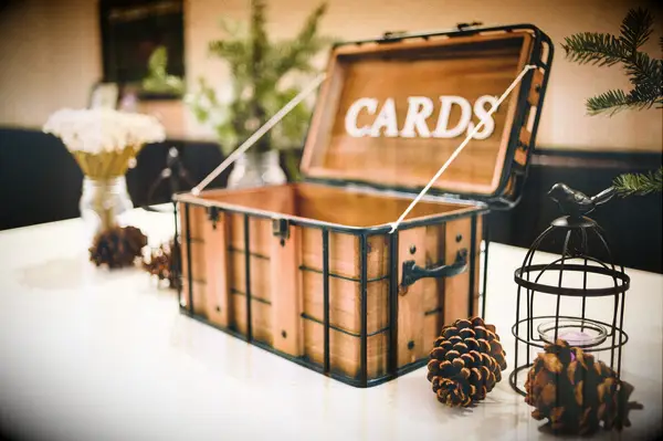 rustic wooden crate wedding card box with pinecones and winter greenery