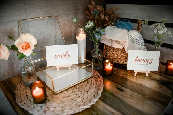 wedding gift table with gold glass card box, votive candles and wedding favors in wicker basket