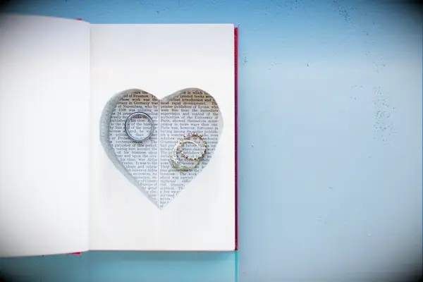 Cut out heart in book with rings