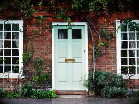 teal front door on brick house