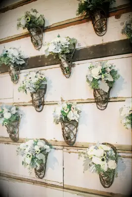 Bouquets of white flowers hung in rustic wooden baskets.