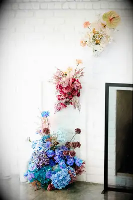 A blue, pink and yellow flower wedding installation.