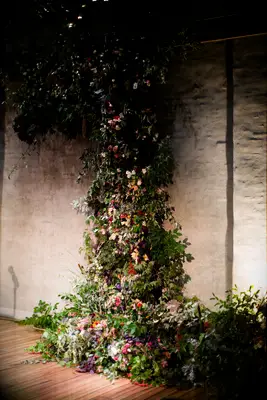 A wildflower and greenery flower wall installation at a wedding. 