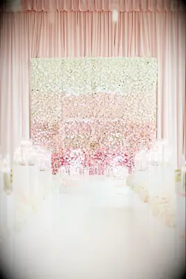A large white and pink flower wedding backdrop at a ceremony. 