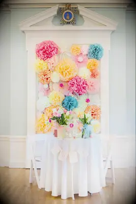 A bright paper flower backdrop behind the sweetheart table.