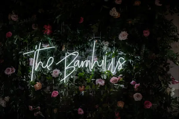 Neon sign on a rose wedding flower wall.