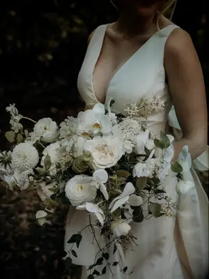 Bride holding boho white wedding bouquet