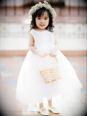 Flower girl in white dress with basket and flower crown