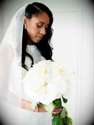 Bride with veil holding white bouquet