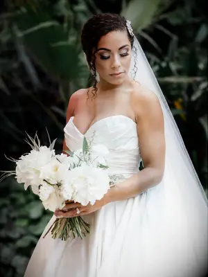 Bride with updo and veil holding white bouquet