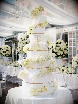 Ten-tier white and gold wedding cake with fresh flowers