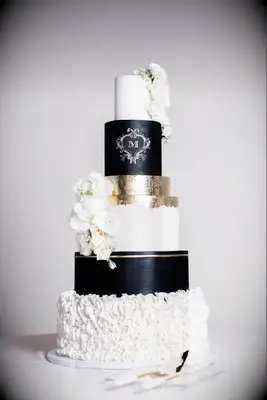 Sophisticated six-tier wedding cake in white, black, and gold