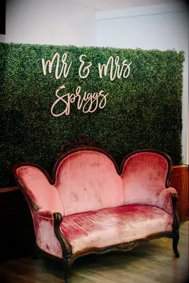 Boxwood wall with velvet sofa for photo booth