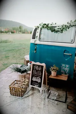 Blue VW bus with chalkboard sign and rustic decorations