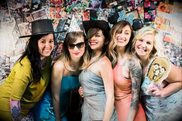 Guests pose in front of custom comic book photo booth backdrop. 