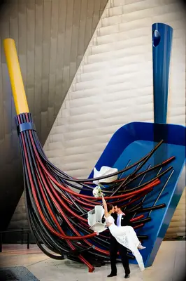Couple poses in front of funky sculpture for a modern photo booth. 
