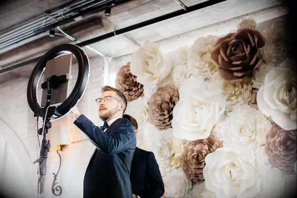 Guest taking selfie on iPad in front of faux flower wall