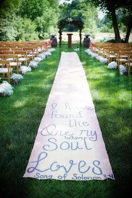 Burlap aisle runner featuring a hand-painted romantic phrase. 