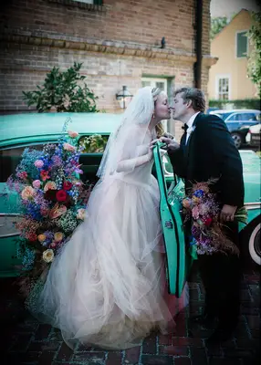 Dramatic floral decorations on electric blue antique car
