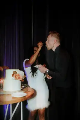 A couple feed wedding cake to each other