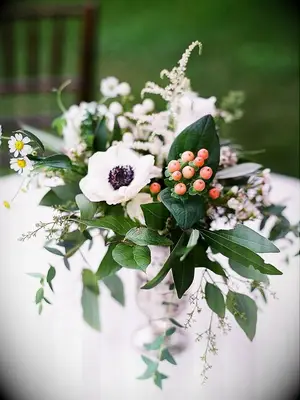 Centerpiece with anemone, hypericum, greenery and astilbe