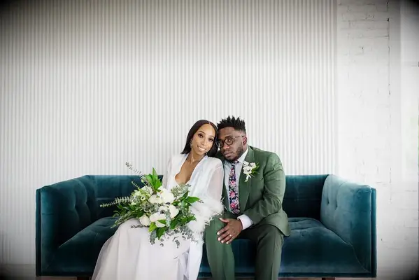 Couple sitting on couch holding bouquet