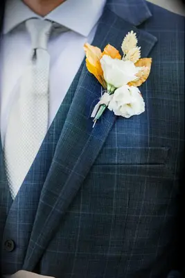 Boutonniere with white flower and dried leaves