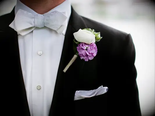 purple camellia and white rose boutonniere