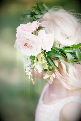 side view of flower girl wearing a crown with pink garden roses, greenery and white pieris japonica