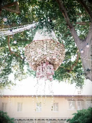 flower chandelier made with blush roses hanging in a tree at outdoor wedding venue