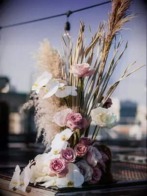 modern abstract wedding flower centerpiece with pampas grass, white phalaenopsis orchids and light pink roses
