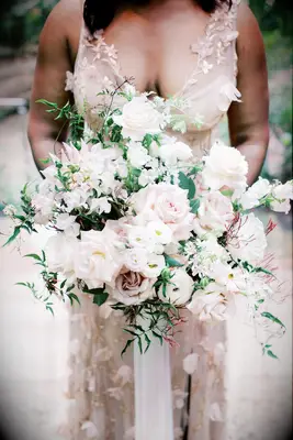 bride holding romantic garden style wedding bouquet with blush roses, jasmine vines and white lisianthus