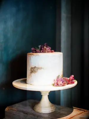 modern one tier wedding cake with white and brown marble design and purple flowers