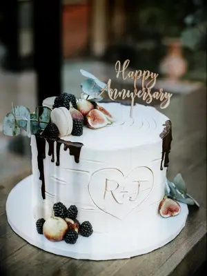 rustic one tier wedding cake with carved initials inside heart 