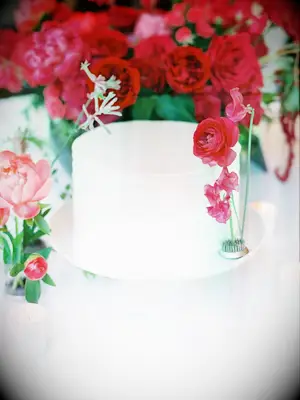 modern one tier wedding cake decorated with pink bougainvillea and ranunculus 
