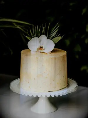 tropical one tier wedding cake with yellow frosting and white orchid on top