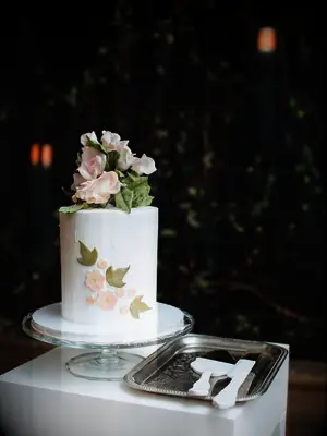 one tier wedding cake with pink sugar flowers and green ivy leaves