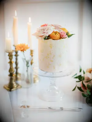 small one tier wedding cake with gold leaf, textured fondant and pink and orange flowers