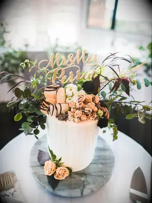 one tier wedding cake with chocolate pieces, cookies and popcorn on top