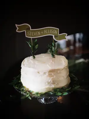 buttercream one tier wedding cake with custom banner-style cake topper with couple